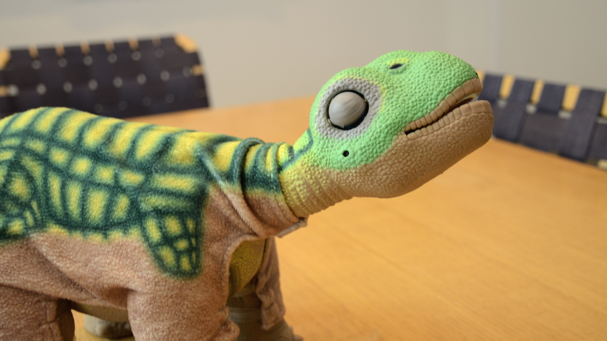 A Pleo robot comfortably stretching his body.