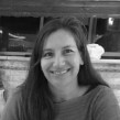 Black-and-white close-up portrait of a smiling smiling woman facing the camera.