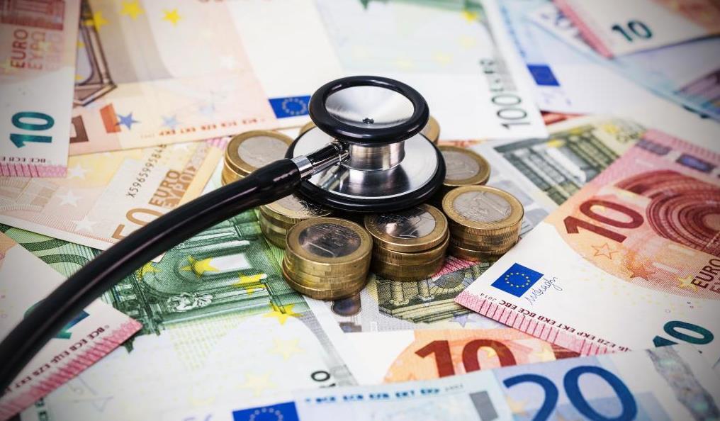 Stethoscope placed on euro banknotes and coins.
