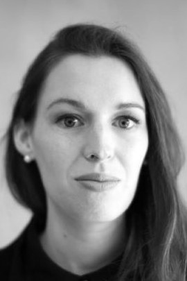 Black-and-white close-up headshot of a woman looking at the camera.