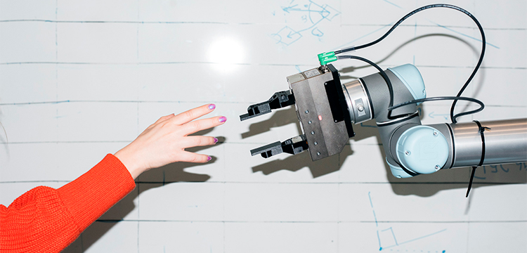 Et foto af en menneskearm og en robotarm, som rækker fingrene frem for at røre hinanden