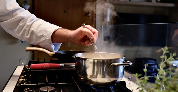 Person der laver sovs på et gaskomfur.