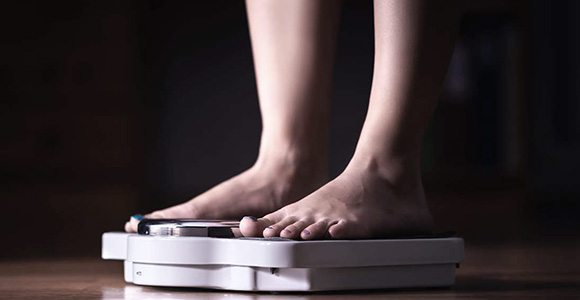 Person der står på en vægt i bare fødder.