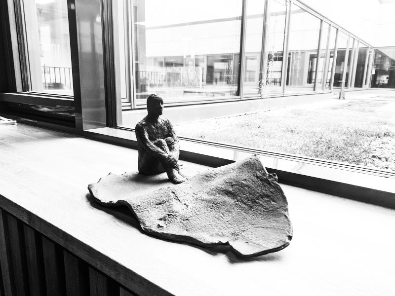 sculpture of a person sitting down looking worried