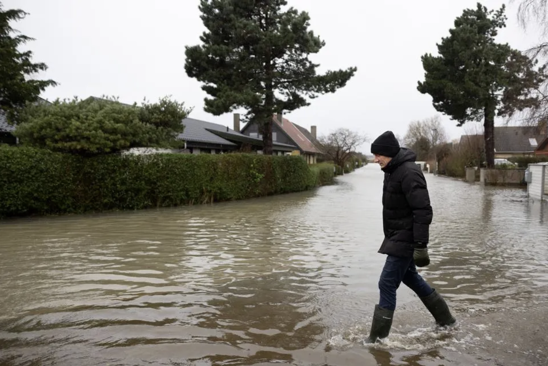 Billede af mand der går på vej der er oversvømmet