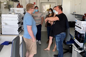 Group of people in a laboratory discussing equipment during a lab tour.