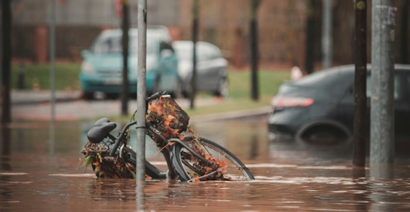 Road totally flooded. Bicycle standing against a lamp-post half covered with water