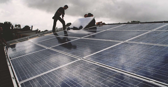 Man standing on a roof with solar panels