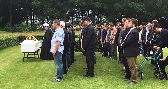 Billedet viser en stor gruppe mænd til begravelse.