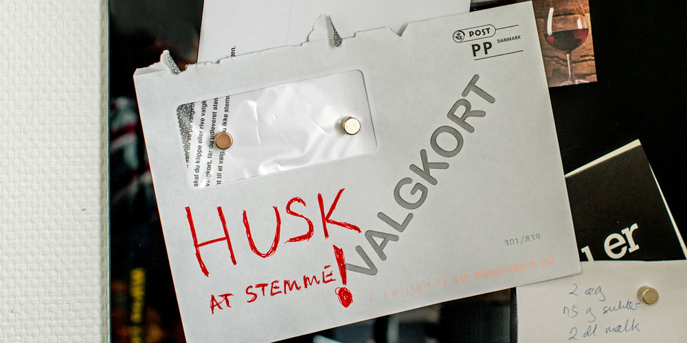 Billede af konvolut med valgkort, hvor der med rød tekst er skrevet "Husk at stemme!" 