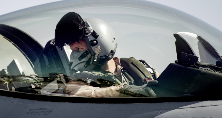 Billedet viser en pilot i cockpittet på et kampfly.
