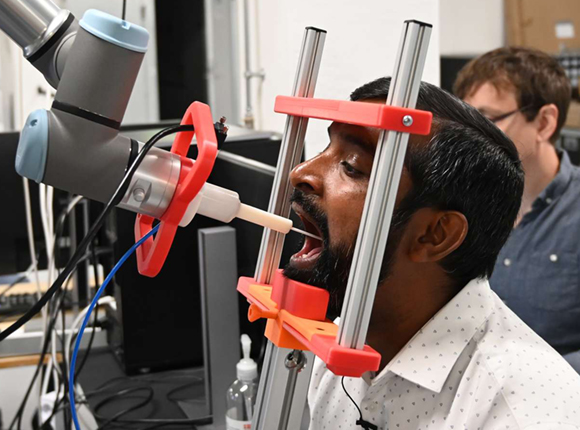 Picture of Thiusius Rajeeth Savarimuthu getting a throat swab by the world’s first fully automatic robot that can carry out throat swabs for Covid-19.