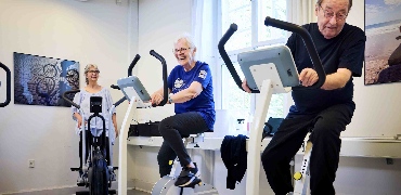 Ældre træner på kondicykler og griner