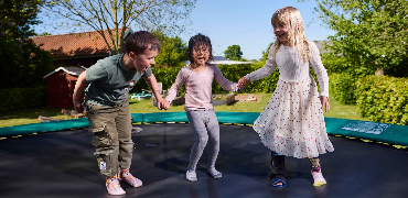 Tre børn hopper på en trampolin