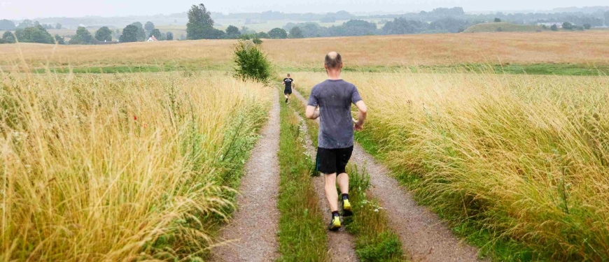 To personer løber ud over mark i et hjulspor