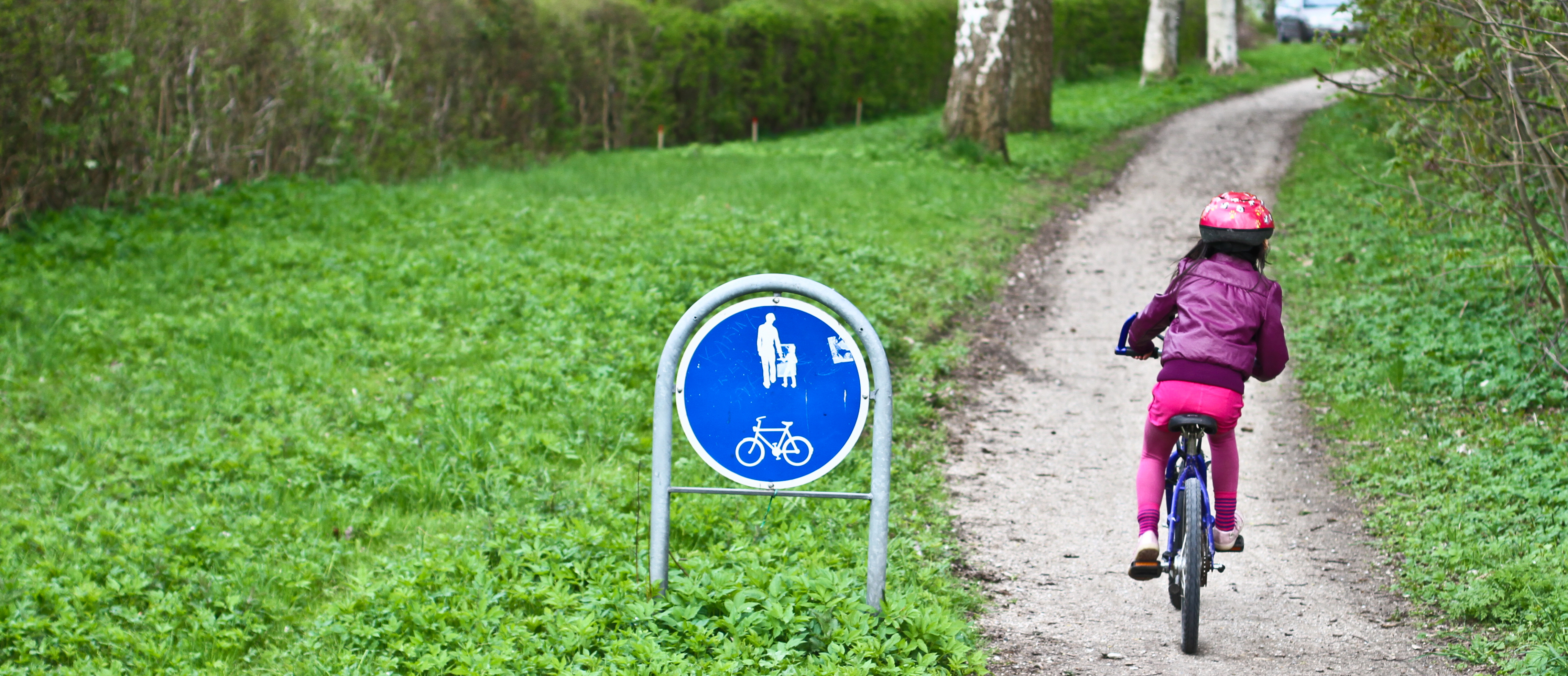 Pige cykler på en sti forbeholdt cykler og gående