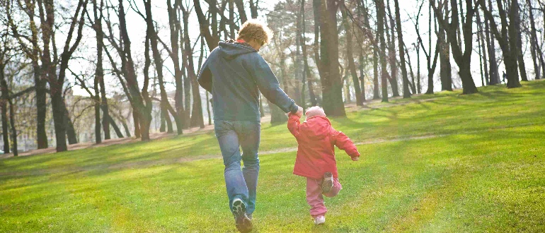 Far og barn løber på græsset