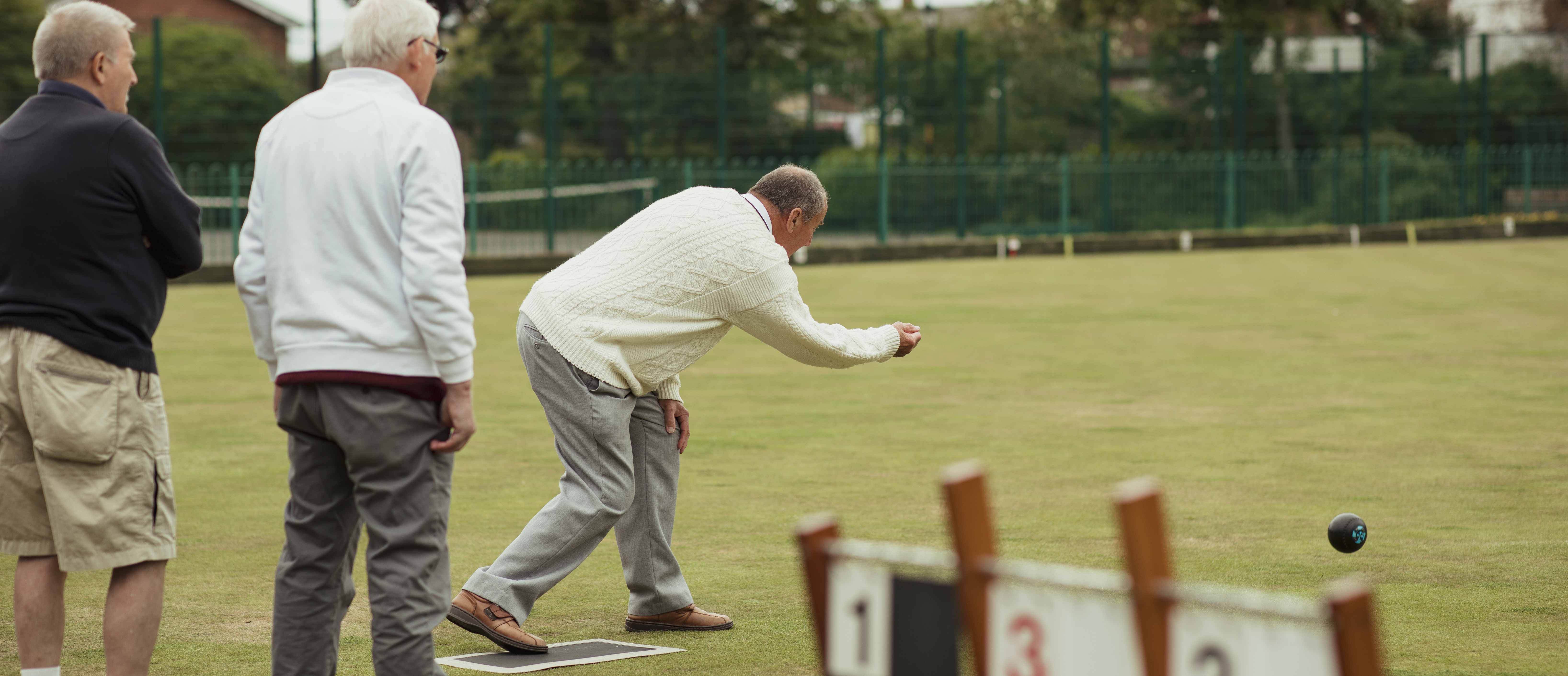 En ældre mand, der tager sit kast i keglebold