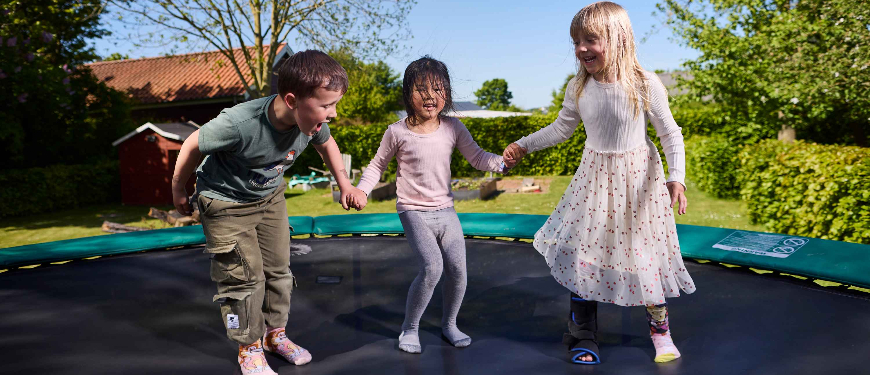 Tre børn hopper på en trampolin