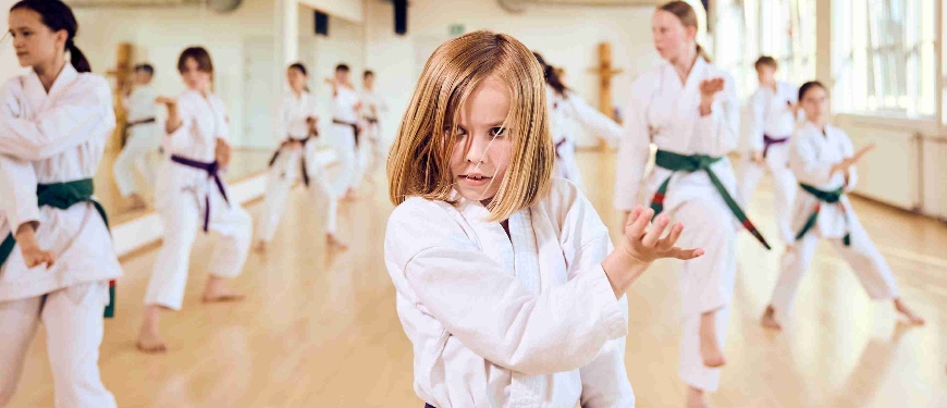 Pige dyrker kampsport på et hold med mange andre piger