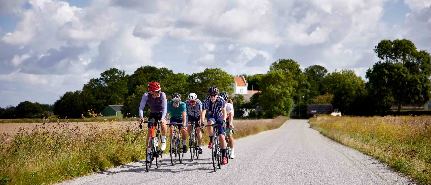 Gruppe af mænd cykler sammen i dansk landskab