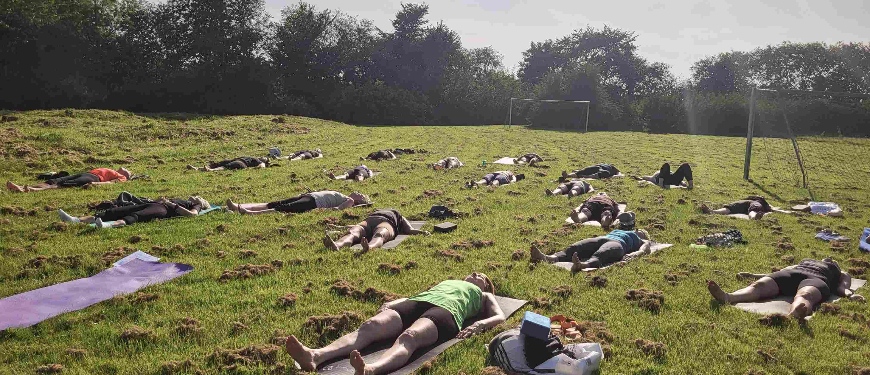 Personer ligger på græsmark