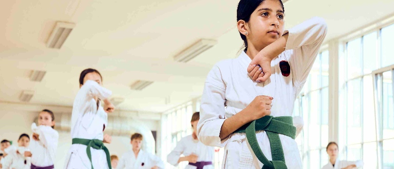 Piger laver kampsport iført hvid gi 