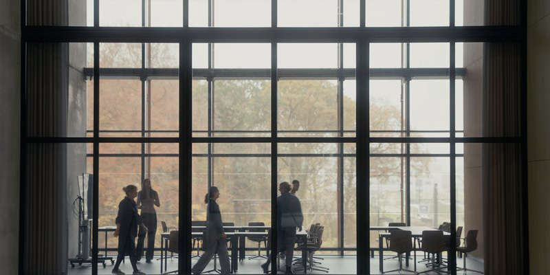 People in front of the windows at the main entrance of SDU Campus Odense