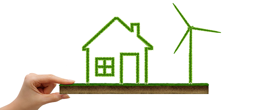 Hand holding green land with grass covered house icon - Colourbox.com / Marina Bolow