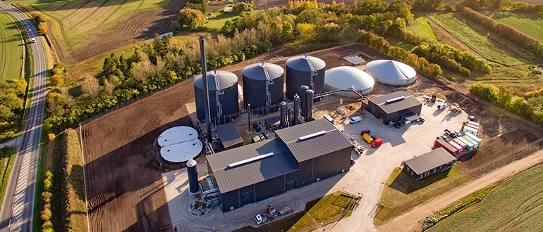 Aerial view of an industrial facility with large tanks and domes in a rural area.
