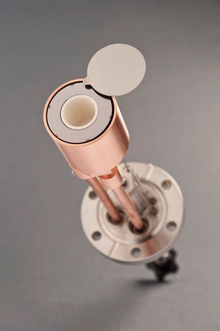 Copper-colored cylindrical metal component with an open cap and circular mounting base on a gray background.