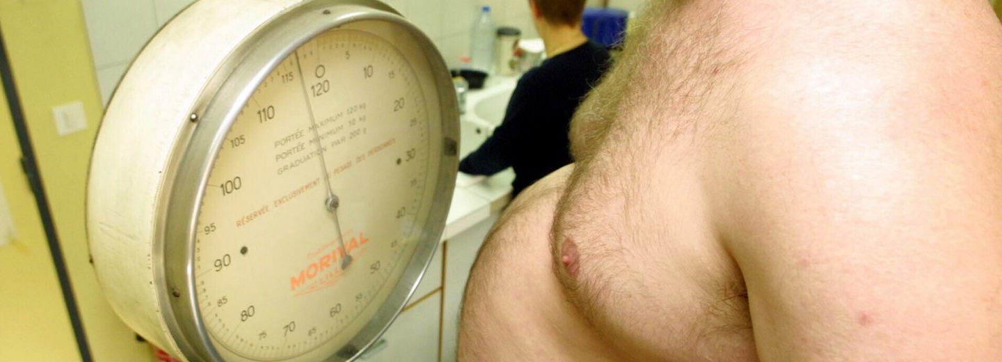 Bar overkrop ved siden af en stor mekanisk klinikvægt med teksten "MORIAL".