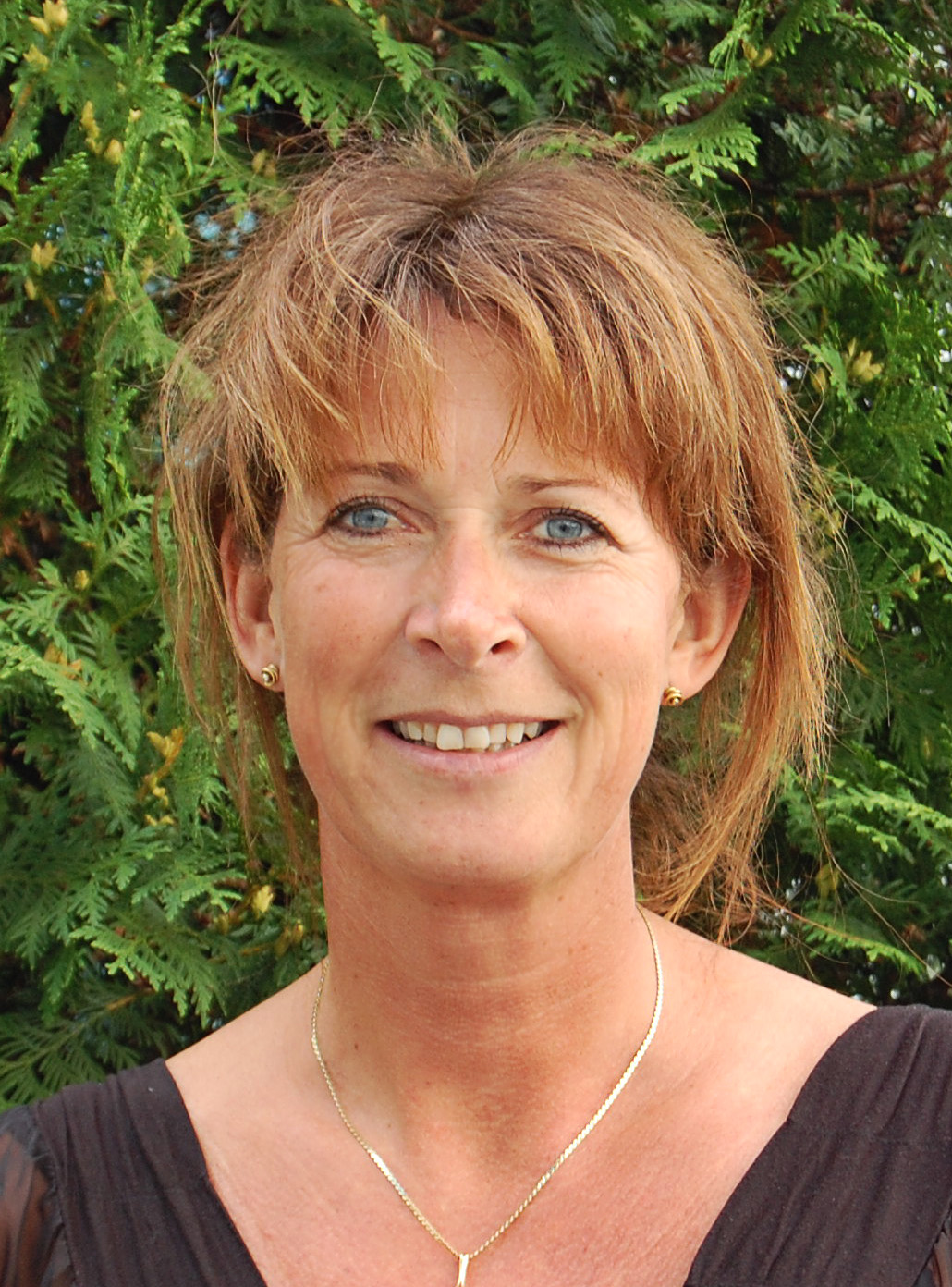 Portræt af Dorthe Nielsen fra SDU_OUH foran grøn beplantning.
