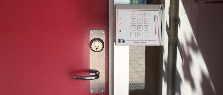 Red door with keypad access panel Red door beside an electronic keypad entry panel labeled "accessCARD®".
