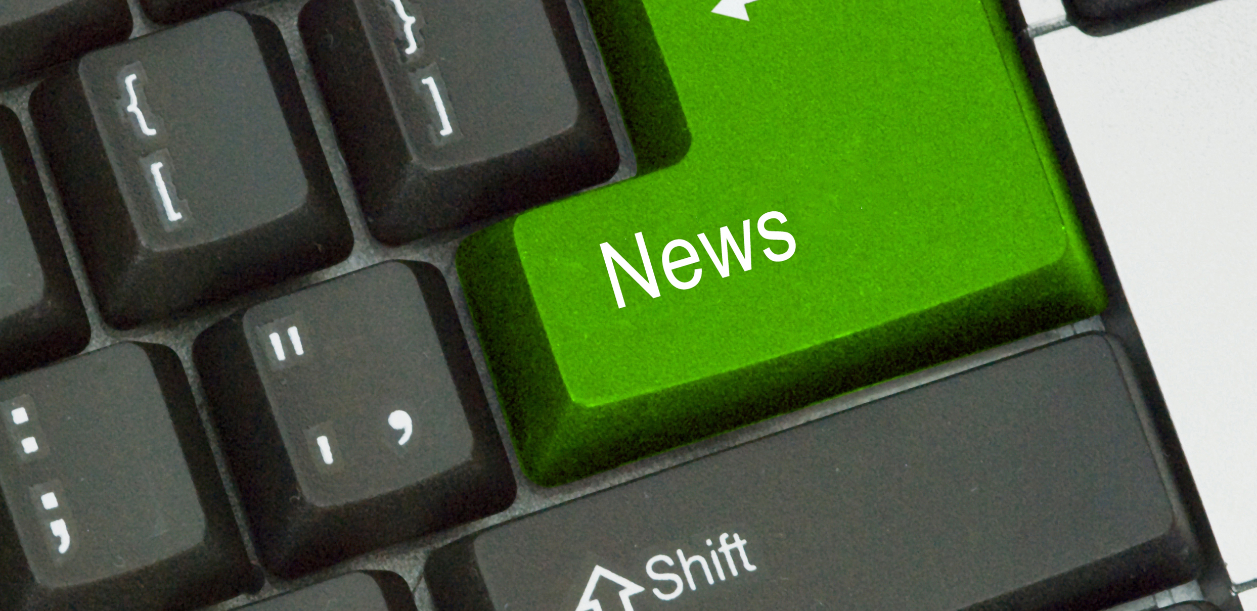 Nærbillede af tastatur med grøn "News"-tast og synlig "Shift"-tast.