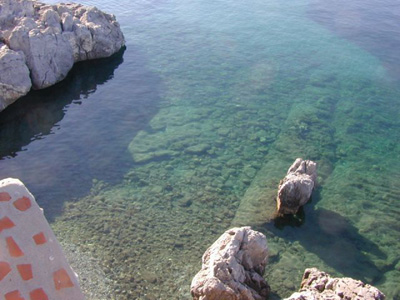 Fig. 31. The small bay on the south shore of the Zephyrion peninsula seen from the north-west. A rock-cut foundation is apparently running obliquely out from the coast on the sea-bottom.