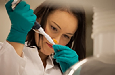 Nærbillede af laboratoriemedarbejder, der bruger en pipette til at håndtere en lille prøve.