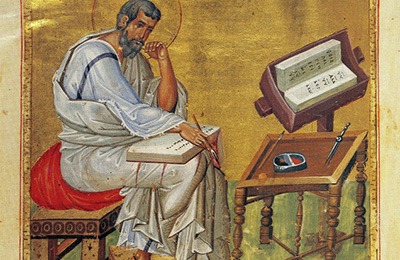 Middelalderlig illustration af evangelisten Matthew, der sidder og skriver med en bog på skødet ved siden af et bord og en læsepult.