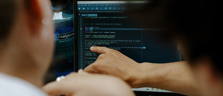 Person pointing at code on a computer screen Person pointing at code on a computer screen with a "nalgene" bottle nearby.