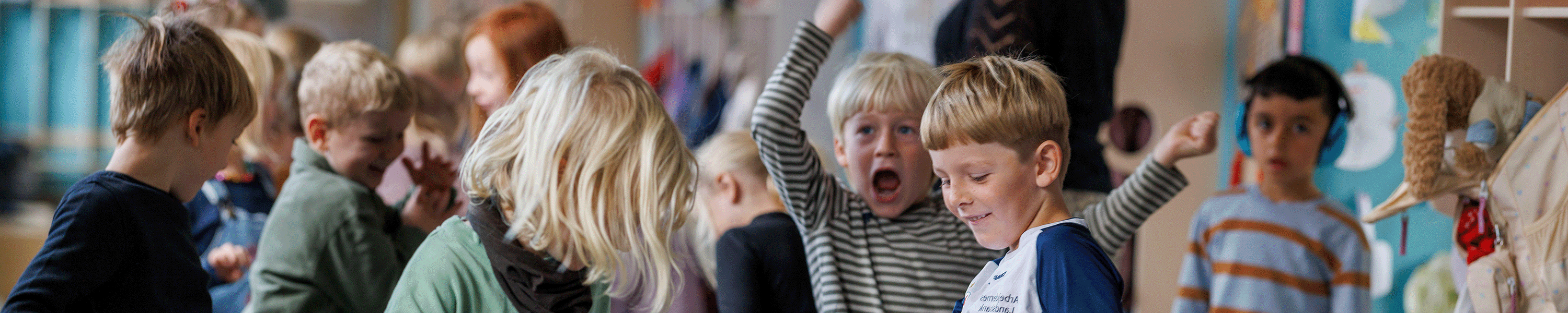 Forside på MOVE magasin nummer 18. Glade børn i indskolingen ved deres garderobe.