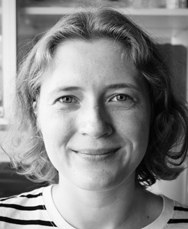 Black-and-white close-up portrait of a smiling woman Black-and-white close-up portrait of a woman with short wavy hair smiling at the camera indoors.