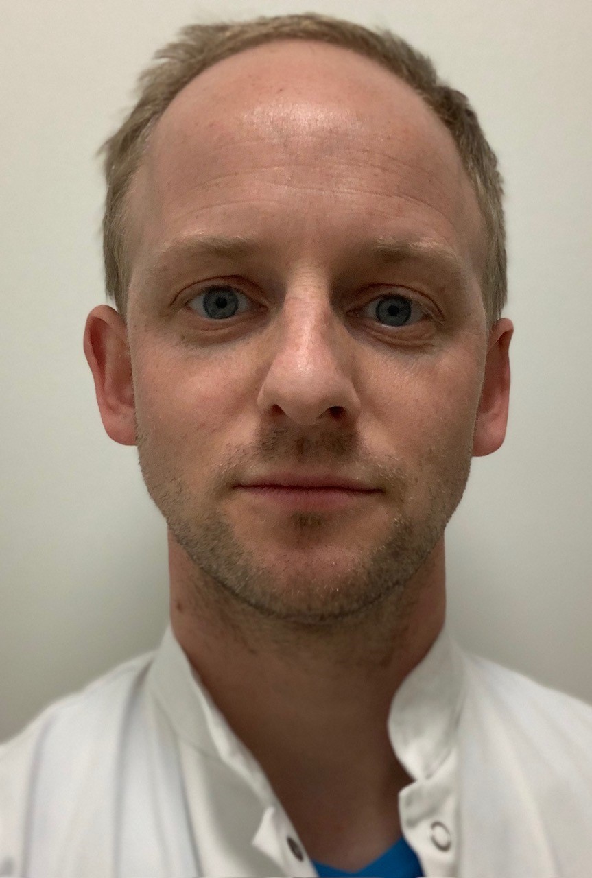 Close-up portrait of jesper-r.-soerensen in a white coat facing the camera.
