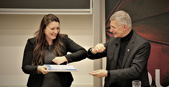 Head of the Mads Clausen Institute, Horst-Günter Rubahn, gives BHJ Innovation Award to Roana M. de Oliveira Hansen with 'Corona handshake'.