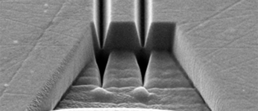 Ion-stråle-fræsede kanaler i guld, brugt som v-kanaler til avanceret plasmonik. Helium-ion mikroskopi.