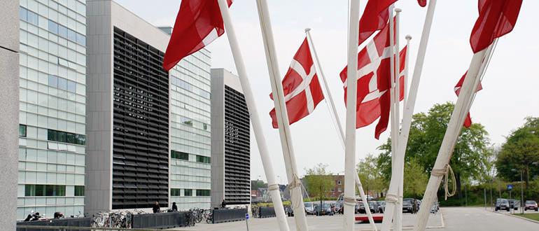 View of Alsion with hoisted Danish flags in front of the main entrance.