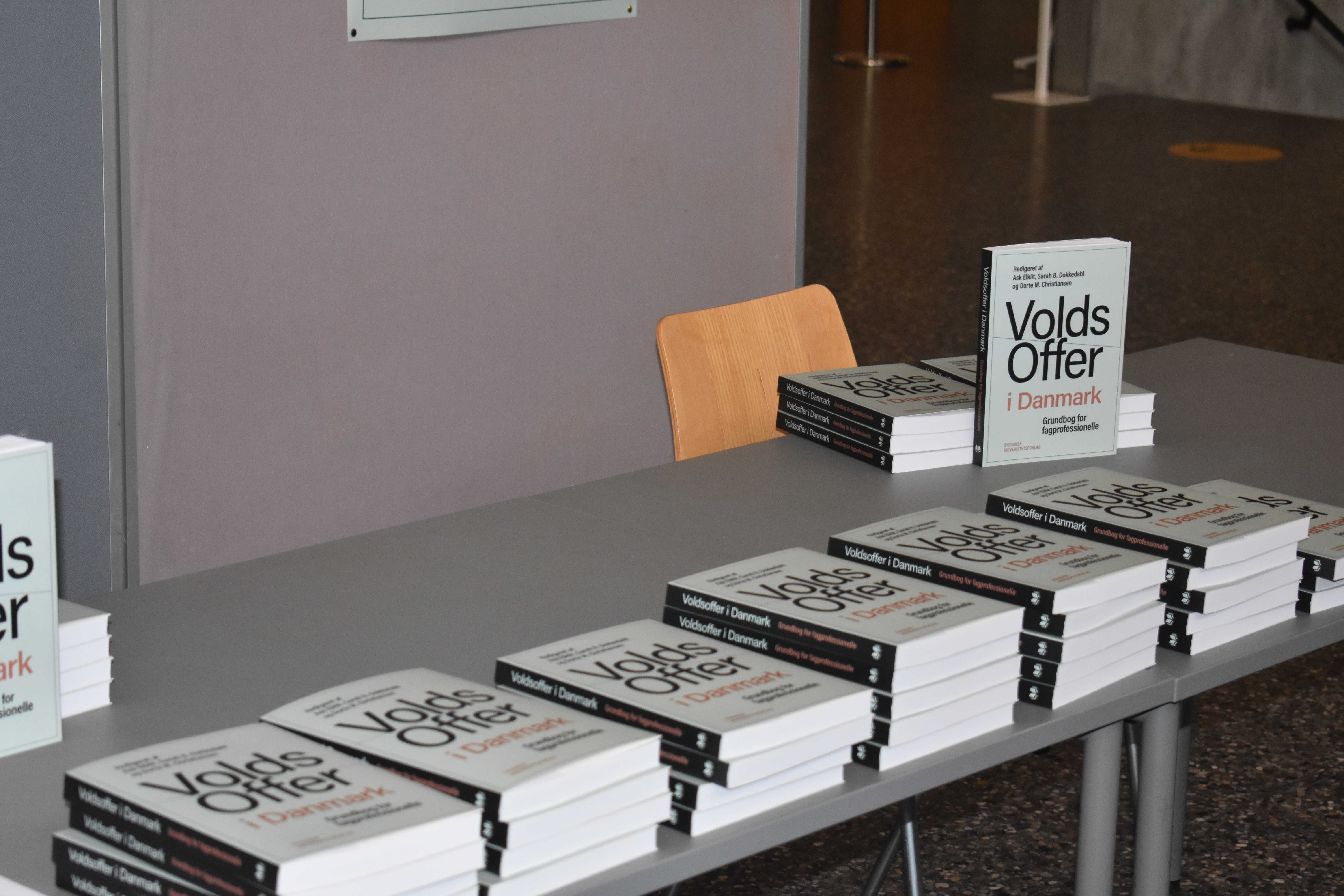 Flere eksemplarer af bogen "Volds Offer i Danmark" ligger stablet på et bord, mens ét eksemplar står oprejst.
