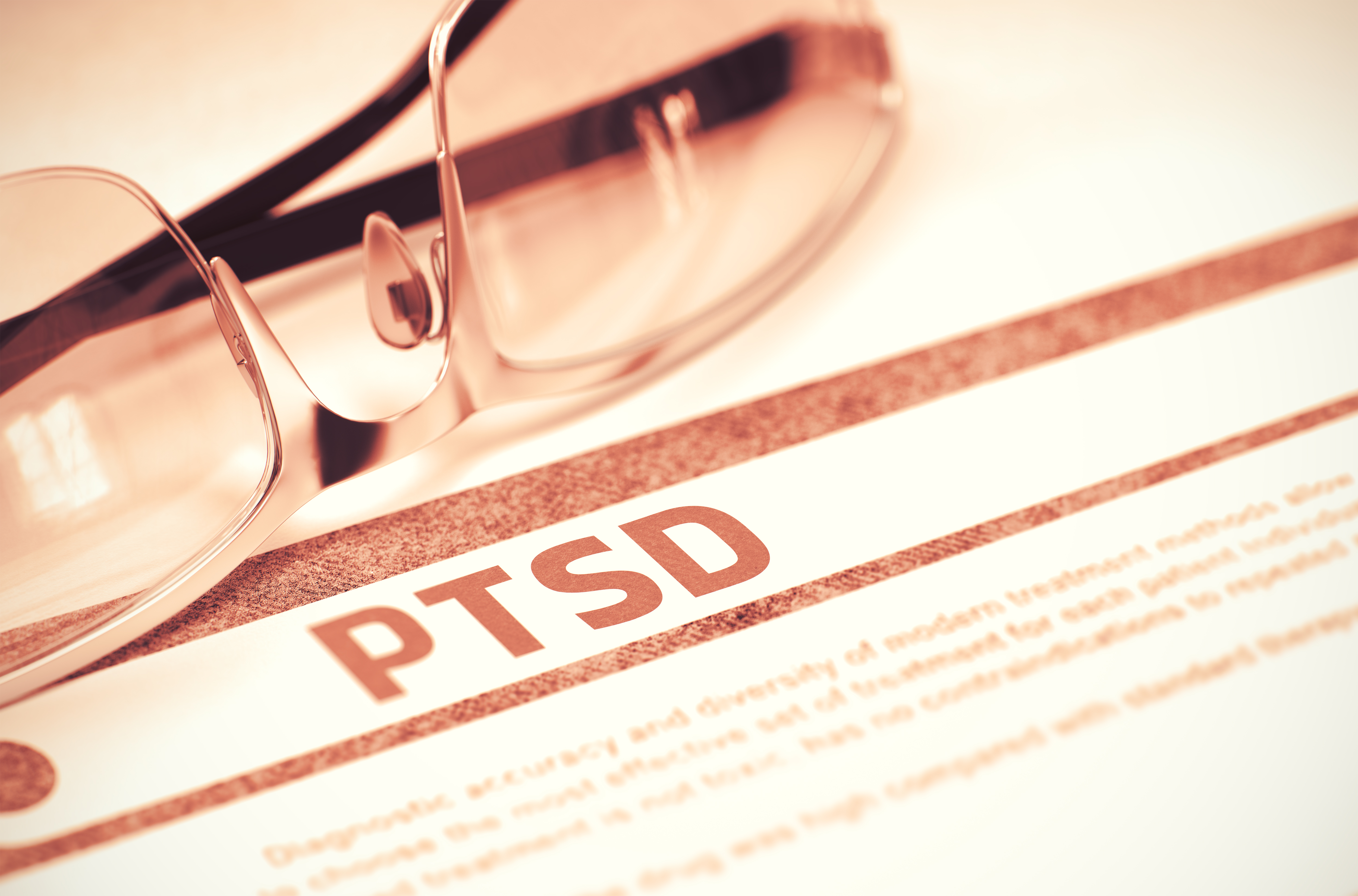 Briller ligger på et dokument med den tydelige tekst "PTSD".
