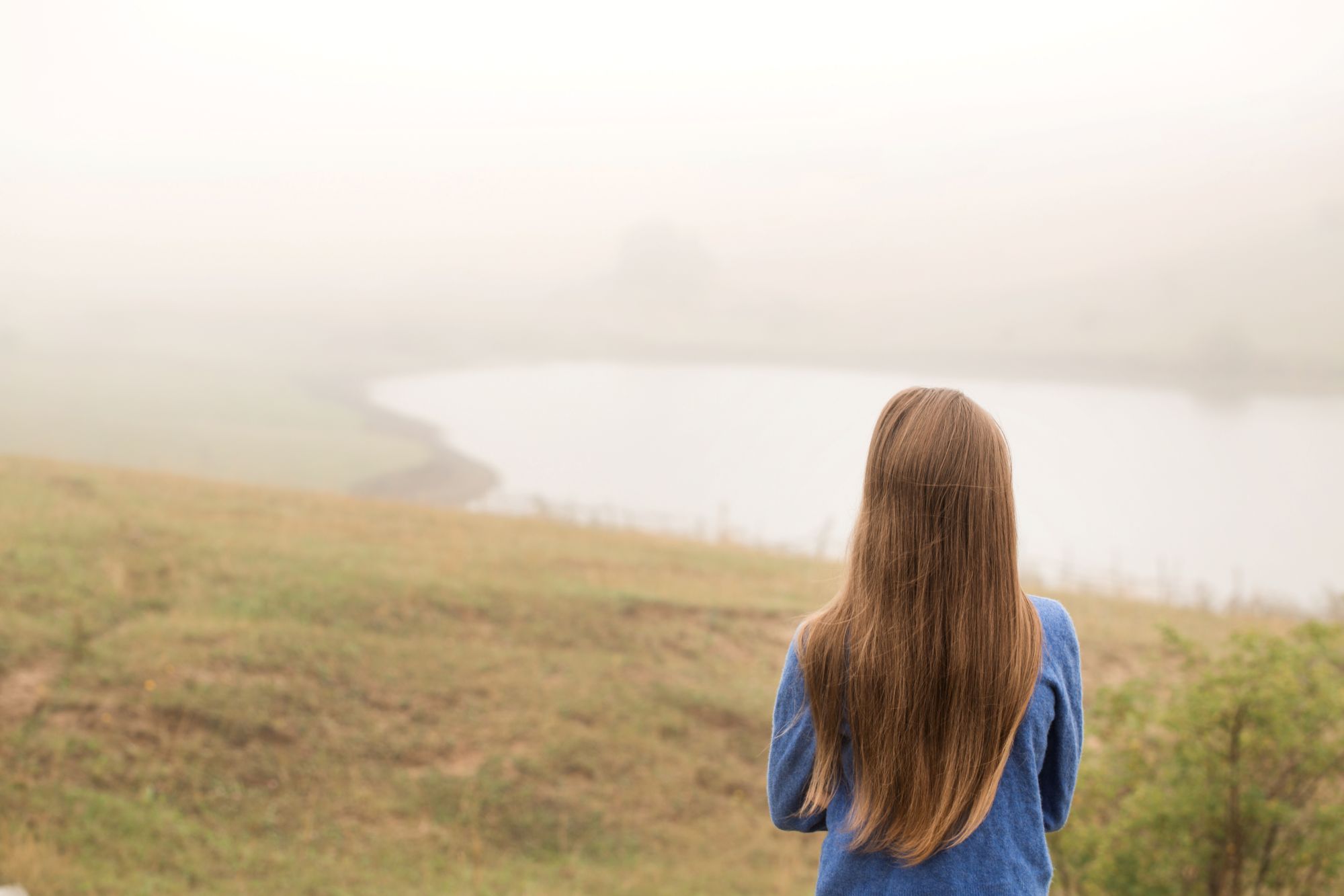 Girl watching a misty landscape