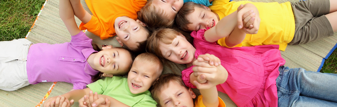 En masse børn ligger på et tæppe