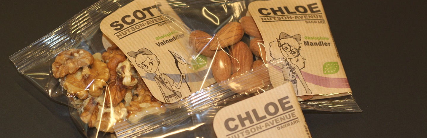 Tre poser med nødder fra NUTSON-AVENUE med etiketterne SCOT og CHLOE, inklusive valnødder og mandler i gennemsigtig emballage.